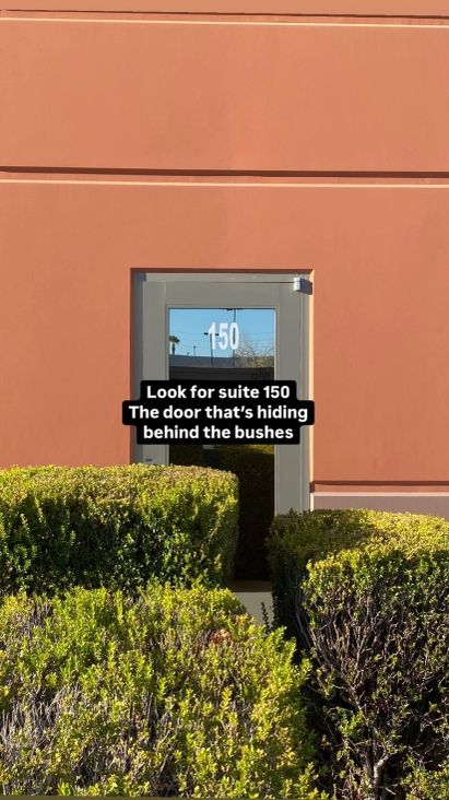 Suite 150 entrance door behind the bushes
